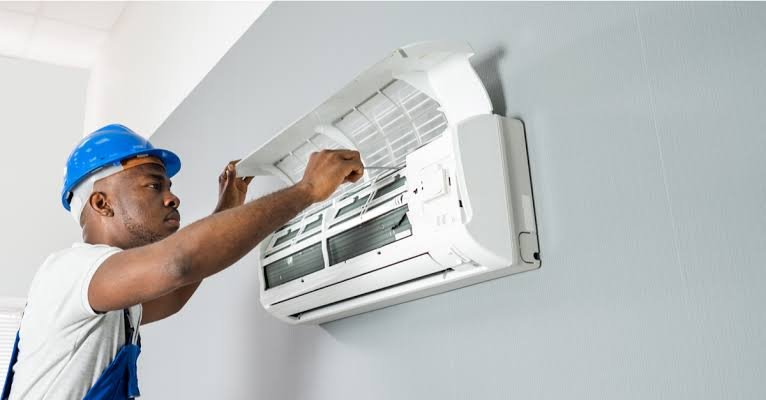 Technician performing AC maintenance